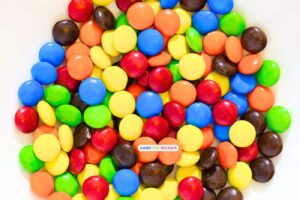 bowl of M&M candies on a Thanksgiving table for the candy Thanksgiving gratitude game for Thanksgiving games